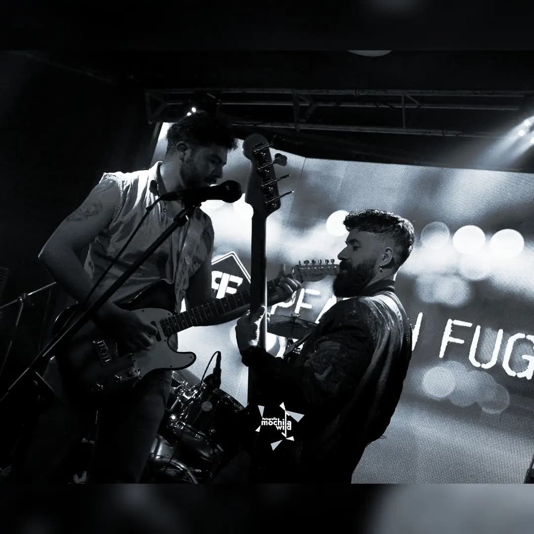 Dos integrantes de la banda frente a frente con sus guitarras